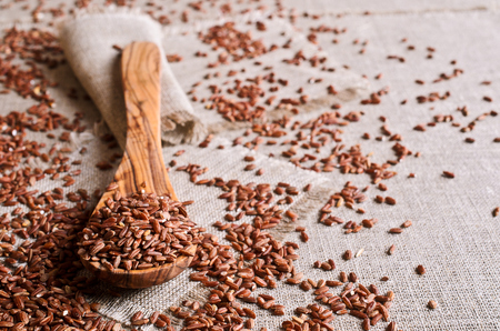Whole raw grain unpolished brown rice in a potの写真素材