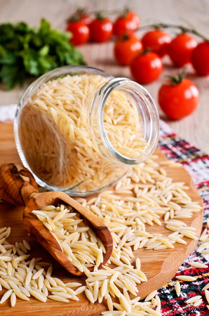 Pasta Orzo in the form of rice grains in a wooden scoopの写真素材