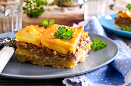 Portion of graten potatoes and minced meat on a ceramic plateの写真素材