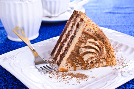 Cut a piece of cake brown with cream on the plateの写真素材