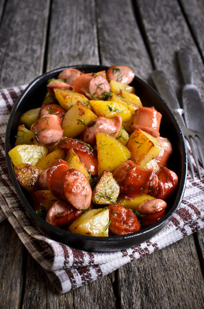 Potatoes with sausages, cut into slices and fried in oil, in rustic styleの写真素材