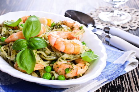 Pasta tagliatelle with shrimp and peas, dressed with sauce "pesto"の写真素材