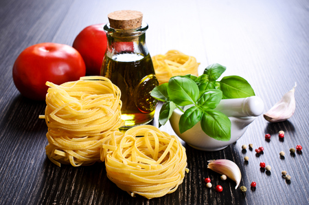 Tagliatelle yellow in dry form in the shape of a nest on a dark backgroundの写真素材