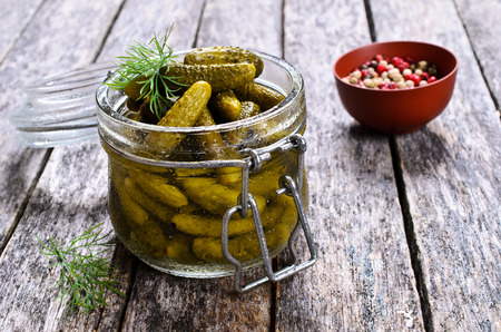 Pickles is a very small amount in a glass jar on a wooden surfaceの写真素材
