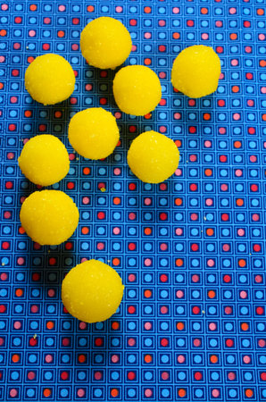 Yellow candy in sugar, round shape. Selective focus.