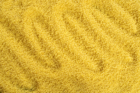 Background of dried yellow fine grains of couscous