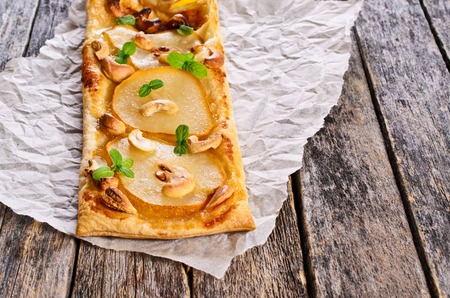 Tart with pears and nuts on the baking paper.の写真素材
