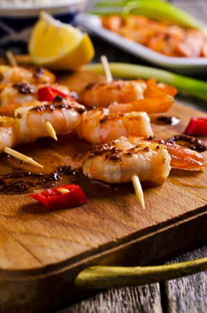 Cooked in a spicy sauce shrimp on skewers. Selective focus.の写真素材
