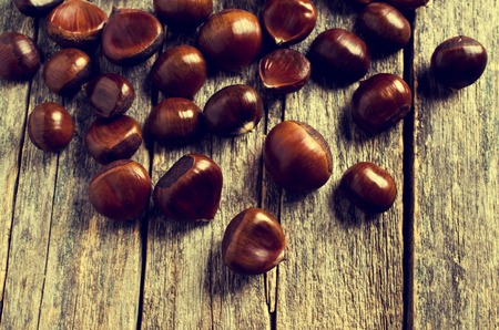 Ripe large chestnuts on a wooden surface. Selective focus.の写真素材