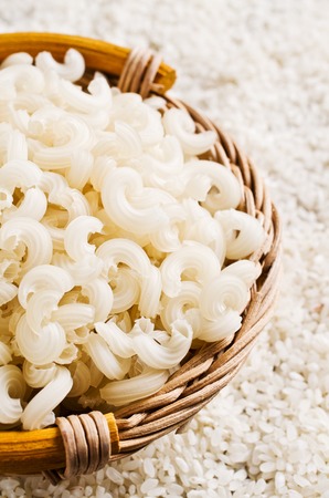 White dry pasta in a pot on a background of rice grains. Selective focus.の写真素材