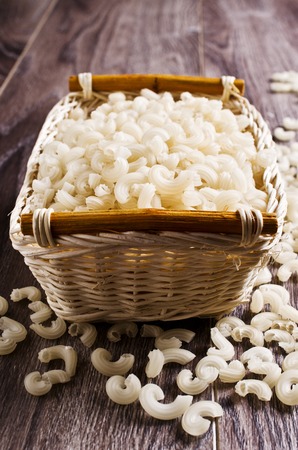 White dry pasta in a pot on a wooden background. Selective focus.の写真素材
