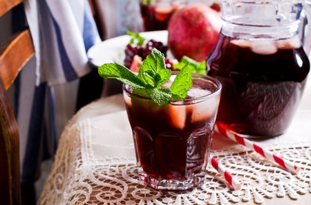 Cold drink of pomegranate in a glass with mint and ice. Selective focus.の写真素材