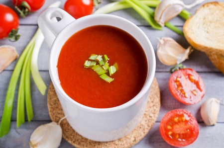 Tomato puree the soup in a ceramic pot on a wooden background. Selective focus.の写真素材