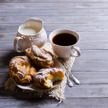 Round cake with cream, sprinkle with powdered sugar,  on a wooden background. Selective focus.