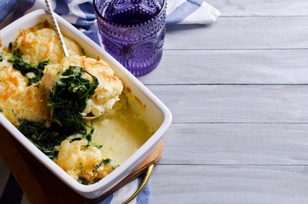 Casserole with cauliflower and spinach on a wooden background. Selective focus.の写真素材