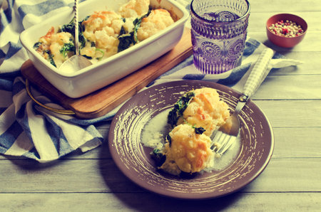 Casserole with cauliflower and spinach on a wooden background. Selective focus.の写真素材