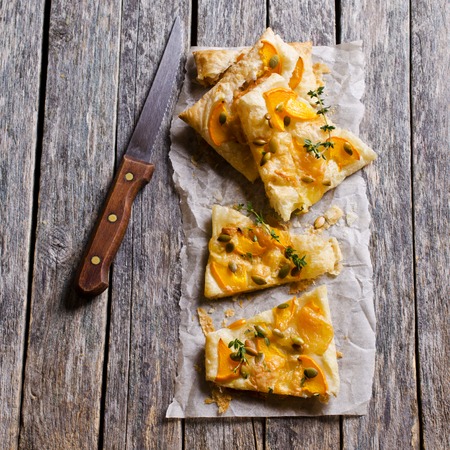 Tart with pumpkin and cheese on wooden background. Selective focus.の写真素材