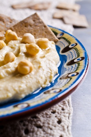 Traditional hummus with chickpeas and dry pieces of pita. Selective focus.の写真素材