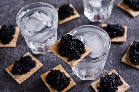 Black caviar on a cracker on a dark background. Selective focus.の写真素材