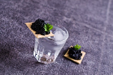 Black caviar on a cracker on a dark background. Selective focus.の写真素材