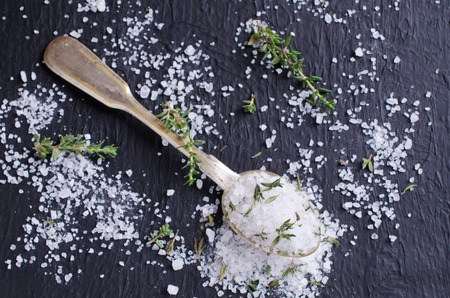 Salt and thyme in spoon on dark background. Selective focus.の写真素材