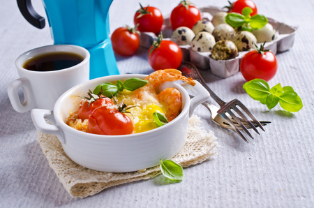 Fried of quail eggs with tomatoes, shrimp and cheese in a batch manner. Selektivgy focus.の写真素材