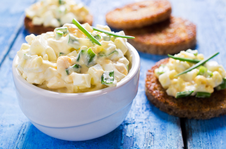 Egg salad with chives on a wooden background. Selective focus.の写真素材