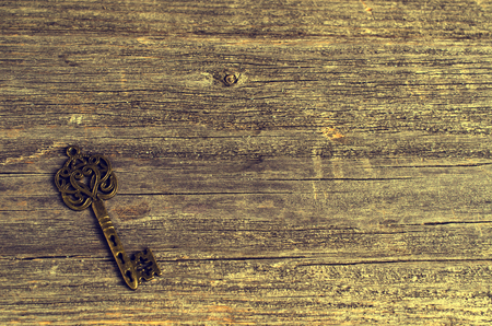 Vintage metal key on a wooden background. Selective focus.の写真素材