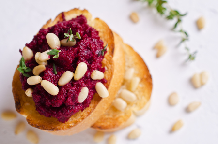 Sandwich with grated beets and nuts on a light background. Selective focus.の写真素材