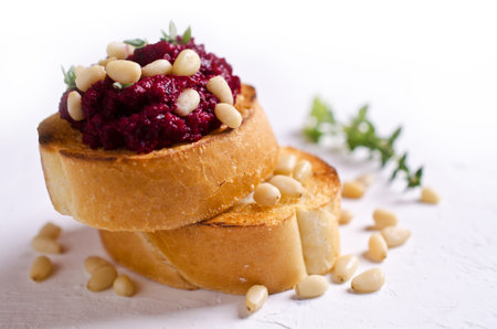 Sandwich with grated beets and nuts on a light background. Selective focus.の写真素材