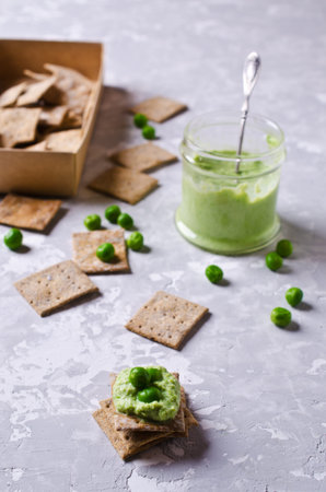 Pea green dip on a cracker. Selective focus.