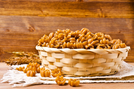 Brown dry pasta in the shape of a flower. Selective focus.