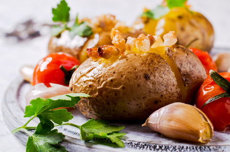 Homemade baked potato with bacon and vegetables. Selective focus.の写真素材