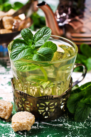 Freshly prepared mint tea out of fresh leaves on wooden background. Selective focus.の写真素材