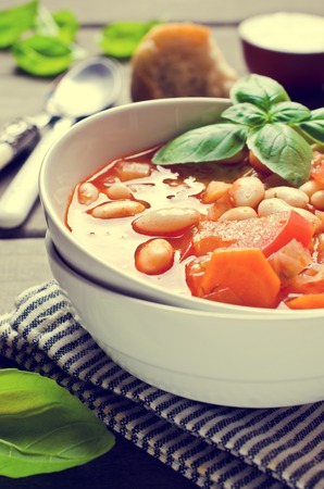 Thick soup with beans and vegetables on a wooden background. Selective focus.の写真素材