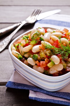 Salad with beans and vegetables in a rustic style on the wooden background. Selective focus.の写真素材