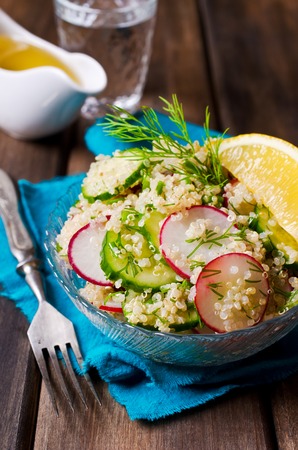 Salad with quinoa and vegetables on a wooden background. Selective focus.の写真素材