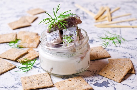 Slices of marinated herring with cream and dill. Selective focus.の写真素材