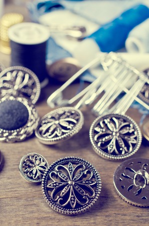Round metal buttons on a background tailoring accessories. Selective focus.の写真素材