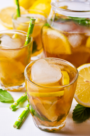 Cold tea with ice, lemon and mint on a wooden background. Selective focus.の写真素材