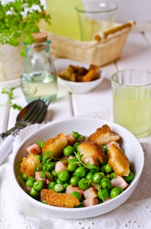 Salad with green peas, bacon and croutons on wooden background. Selective focus.の写真素材