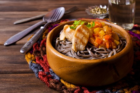 Dark pasta with steamed vegetables and grilled chicken. Selective focus.の写真素材