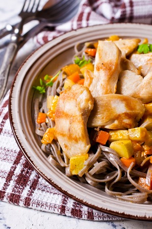 Dark pasta with steamed vegetables and grilled chicken. Selective focus.の写真素材