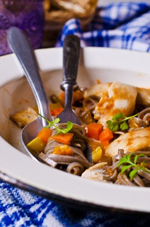 Dark pasta with steamed vegetables and grilled chicken. Selective focus.の写真素材