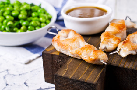Grilled chicken on skewers with garnish of green vegetables. Selective focus.の写真素材