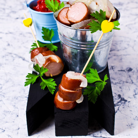 Fried sliced sausages with onion and parsley. Selective focus.の写真素材