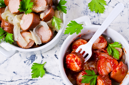 Fried sliced sausages with onion and parsley. Selective focus.の写真素材