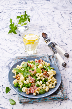 Pasta with bacon and vegetables in portion plate. Selective focus.の写真素材