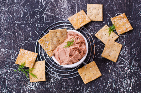 Liver pate with crisps on a dark background. Selective focus.