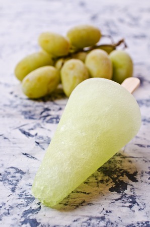 Ice lolly of green grapes on concrete background. Selective focus.の写真素材